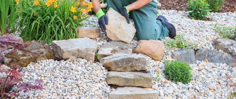 Boulder edging installed around a landscape bed