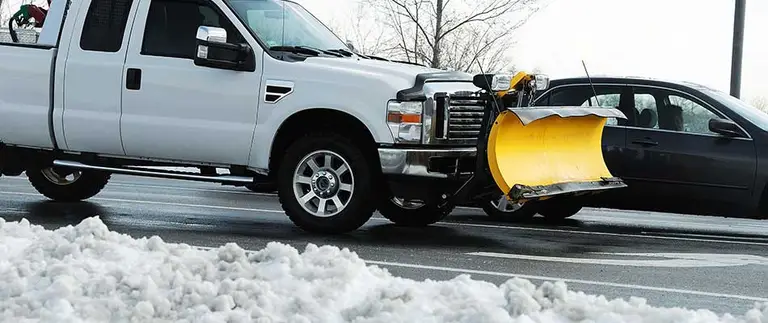 Snow plow truck clearing a parking lot