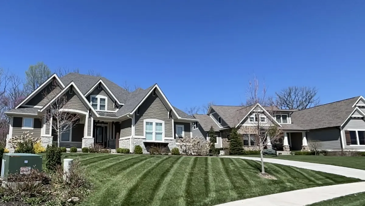 Spring lawn mowing with stripes on a Hamilton County home